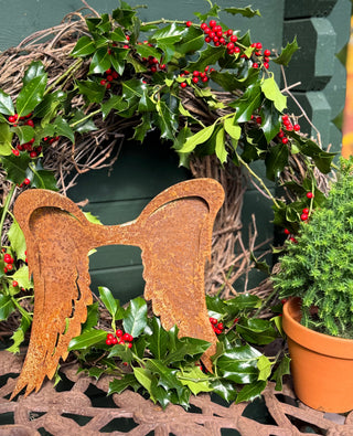 Rebenkranz mit Engelflügeln aus Rost und Ilex an der Haustür